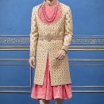 Beige and pink designer groom double layer anarkali pattern sherwani in raw silk surely you can grab attention from everyone inyour wedding function.embellished with thread, zari, embroidared,beads,zardosi and sequins work over it, hook placket, waist belt very alluring in product, full sleeves and straight vented hem. this royal look sherwani inspired from rajputana culcure